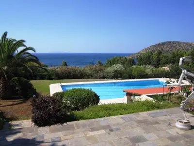 a swimming pool with the ocean in the background at Villa Falmy in Anavissos