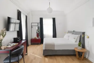 a bedroom with a bed and a desk and a television at Morus Acropolis Boutique Hotel in Athens