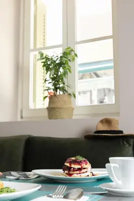 a table with a plate with a sandwich on it at Morus Acropolis Boutique Hotel in Athens