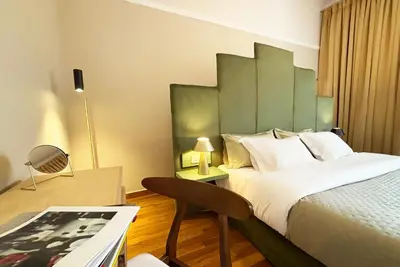 a hotel room with a large bed and a desk at Live in Athens, PANGRATI Fine Residence in Athens
