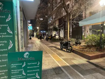 a street with motorcycles parked on the side of a building at Studio in the heart of the city in Athens