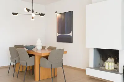 a dining room with a table and chairs and a fireplace at Athenean Boutique Bliss in Athens