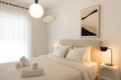 a white bedroom with a bed with towels on it at Athenean Boutique Bliss in Athens