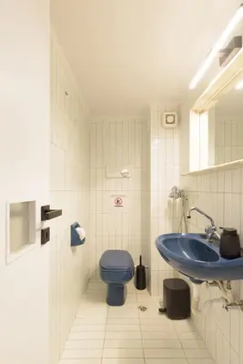 a bathroom with a blue toilet and a sink at Athenean Boutique Bliss in Athens
