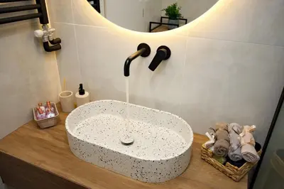 a bathroom with a white sink on a wooden counter at Venus house apart in Pagrati in Athens