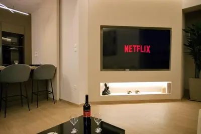 a living room with a television and a table with wine glasses at Venus house apart in Pagrati in Athens