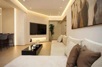 a living room with a white couch and a tv at Venus house apart in Pagrati in Athens