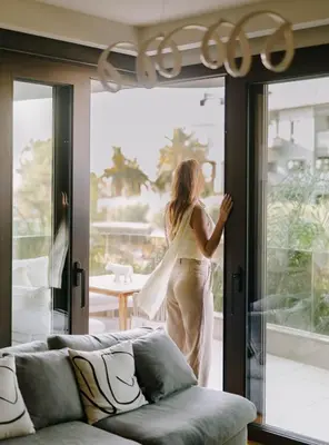a woman is looking out of a window at Aldi Seaside Suite in Athens