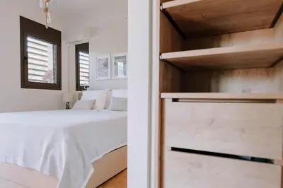 a bedroom with a white bed and a wooden wall at Aldi Seaside Suite in Athens
