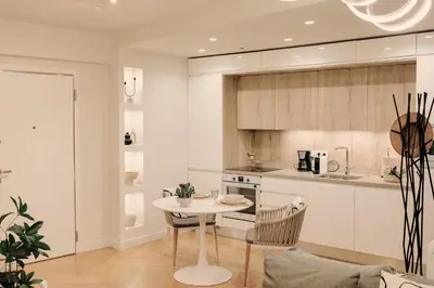 a white kitchen with a table and chairs in a room at Aldi Seaside Suite in Athens