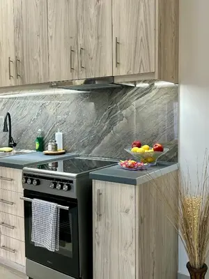 a kitchen with a black stove and a bowl of fruit at Athens Layover Home in Koropíon