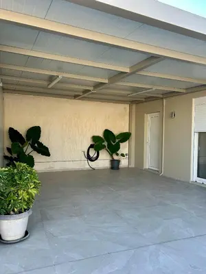 a patio with two potted plants in a building at Athens Layover Home in Koropíon