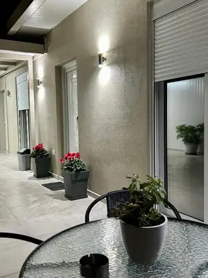 a room with a table and potted plants in a building at Athens Layover Home in Koropíon