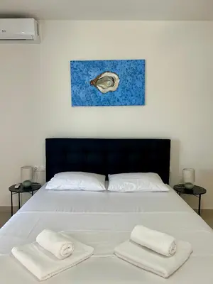 a bedroom with a bed with two towels on it at Athens Layover Home in Koropíon