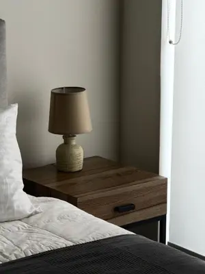 a lamp on a wooden table next to a bed at 1 Bedroom Cozy Studio in Athens