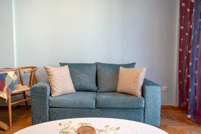 a blue couch in a living room with a table at Central Spot 2-Bedroom Apt by ΜΡS in Athens