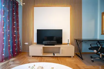 a living room with a flat screen tv on a cabinet at Central Spot 2-Bedroom Apt by ΜΡS in Athens