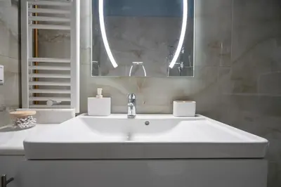 a bathroom with a white sink and a mirror at Central Spot 2-Bedroom Apt by ΜΡS in Athens