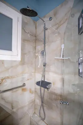 a shower with a glass door in a bathroom at Central Spot 2-Bedroom Apt by ΜΡS in Athens