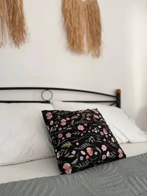 a bed with a black and pink pillow on it at Menta Boho Piraeus Apartment in Piraeus