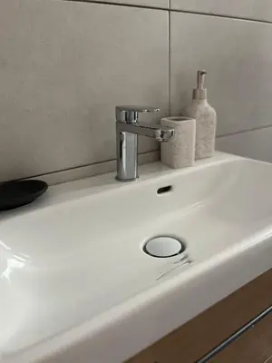 a sink with a faucet and two soap bottles on it at Menta Boho Piraeus Apartment in Piraeus