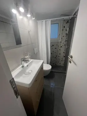 a bathroom with a white sink and a toilet at Menta Boho Piraeus Apartment in Piraeus