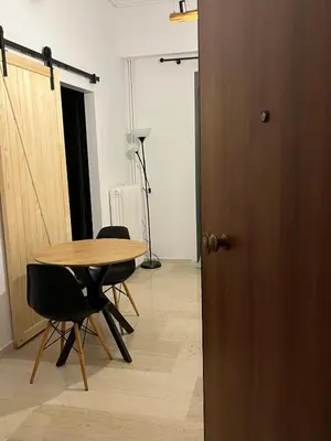 a room with a table and chairs and a door at Menta Boho Piraeus Apartment in Piraeus