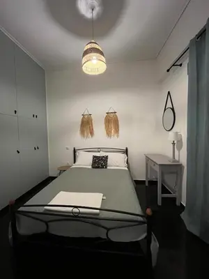 a bedroom with a bed and a table and a lamp at Menta Boho Piraeus Apartment in Piraeus