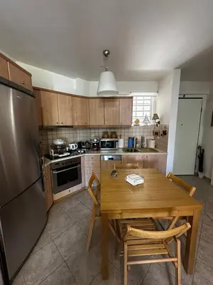 a kitchen with a wooden table and a refrigerator at Saronida Beachwalk Stay in Saronida