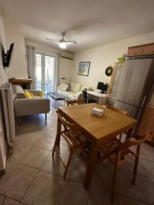 a living room with a table and a couch at Saronida Beachwalk Stay in Saronida