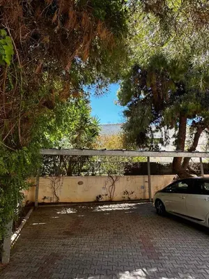 a car parked in a parking lot next to a fence at Saronida Beachwalk Stay in Saronida