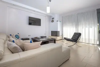 a white living room with a couch and a chair at Villa Anavil - Boutique Coastal Retreat in Varkiza in Vari