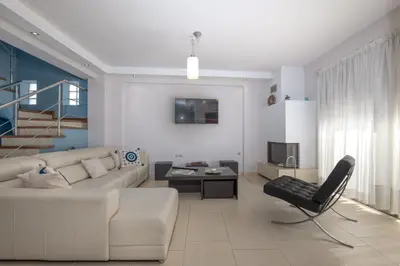 a living room with a white couch and a table at Villa Anavil - Boutique Coastal Retreat in Varkiza in Vari