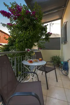 a table and chairs on a balcony with flowers at Villa Anavil - Boutique Coastal Retreat in Varkiza in Vari