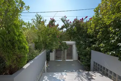 a garden with a garage and some bushes at Villa Anavil - Boutique Coastal Retreat in Varkiza in Vari