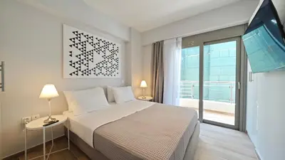 a bedroom with a large bed and a large window at Costa Voula Shared Pool & Beach Apartment A2 in Athens