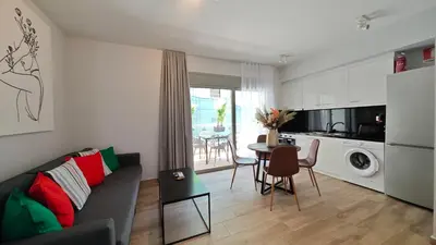 a living room with a couch and a table at Costa Voula Shared Pool & Beach Apartment A2 in Athens
