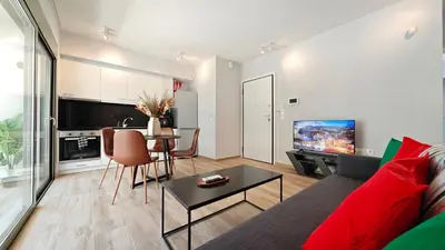 a living room with a red couch and a table at Costa Voula Shared Pool & Beach Apartment A2 in Athens