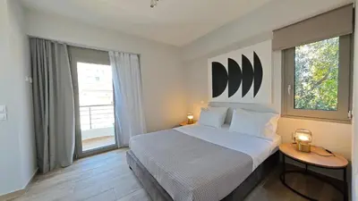 a bedroom with a large bed and a large window at Costa Voula Shared Pool & Beach Apartment A2 in Athens