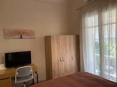 a bedroom with a bed and a dresser with a television at Cozy Acropolis backyard haven in Athens