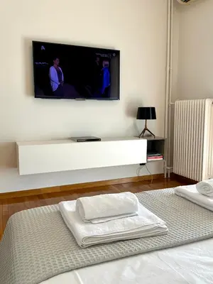 a tv on a wall above a bed with towels at Etherion Luxury Rooftop Balcony Penthouse in Athens in Athens
