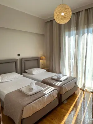 a bedroom with two beds and a chandelier at Etherion Luxury Rooftop Balcony Penthouse in Athens in Athens