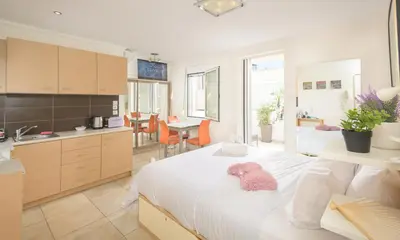 a bedroom with a white bed with a pink stuffed animal on it at Cozy 6th floor, city center, 30m2, sun terrace in Athens