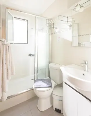 a white bathroom with a toilet and a sink at Cozy 6th floor, city center, 30m2, sun terrace in Athens