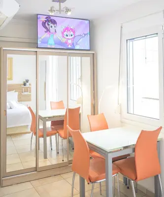 a dining room with a table and chairs and a tv at Cozy 6th floor, city center, 30m2, sun terrace in Athens