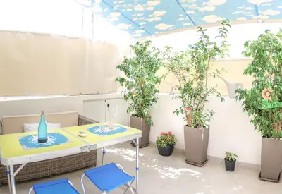 a table and chairs in a room with potted plants at Cozy 6th floor, city center, 30m2, sun terrace in Athens