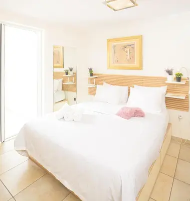 a bedroom with a large white bed with towels on it at Cozy 6th floor, city center, 30m2, sun terrace in Athens