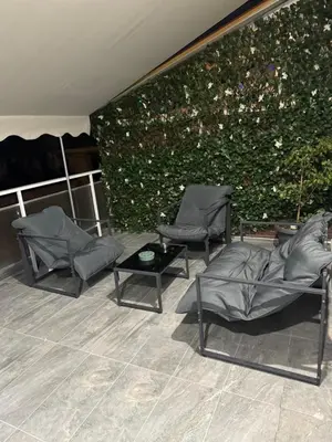 two chairs and a table in front of a green wall at Andys house in Athens