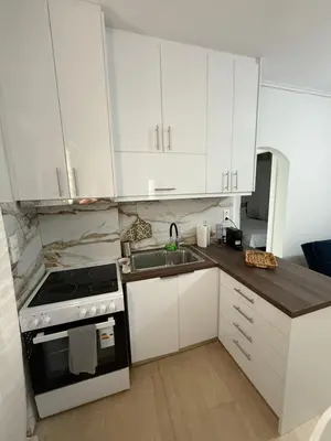 a kitchen with white cabinets and a sink and a stove at Andys house in Athens