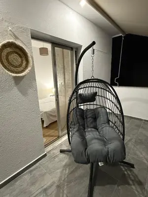a black chair sitting in the middle of a room at Andys house in Athens